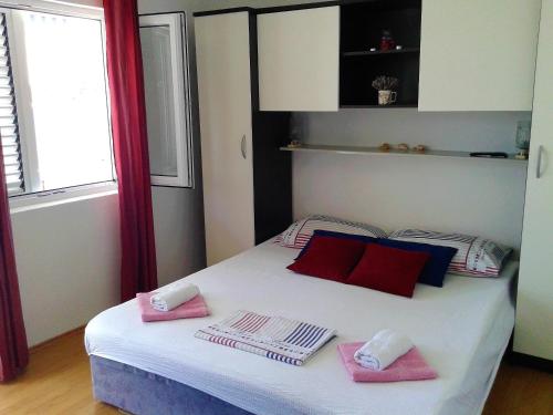 米欧纳Apartment Vesna的一间卧室配有带粉红色毛巾的床
