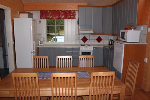 VarpaisjärviKuusitorppa的厨房配有木桌、椅子和微波炉