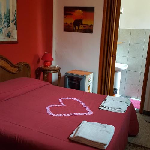 布林迪西bebvialata的一间卧室,配有红色的床,上面有心