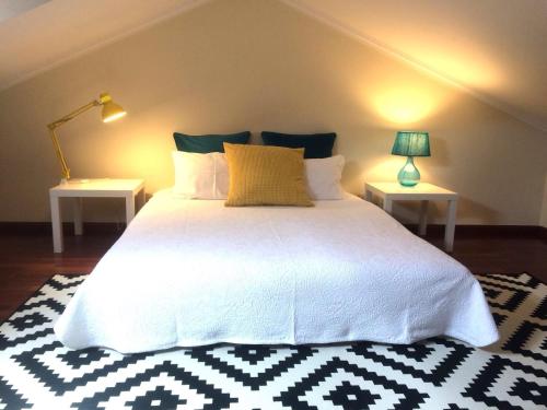 维亚纳堡Apartment Vedória的卧室配有一张带两张桌子的大型白色床