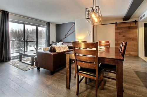 博普雷INITIAL - OLYMPIQUE - Mont-Sainte-Anne的客厅配有桌子和沙发