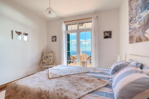 卡尼索Villa Atalaia by HR Madeira的一间卧室设有一张床,享有海景