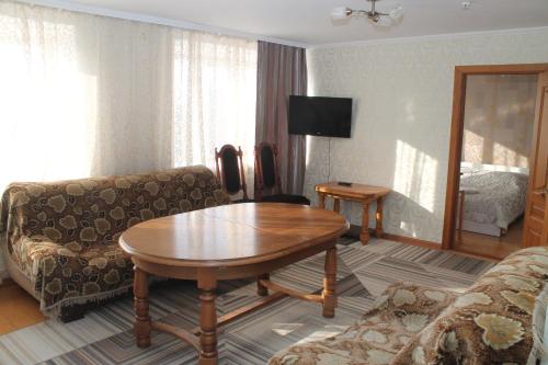 塞米伊Semey Hotel的客厅配有桌子和沙发