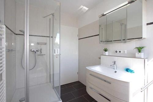 Neu GaarzWohnung Albatros im Haus Wassermann的带淋浴和盥洗盆的白色浴室