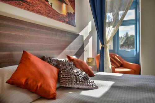 圣朱利安斯Central Suites St. Julian's的一间卧室配有带橙色枕头的床和窗户。