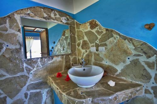 苏莎亚望海住宿加早餐旅馆的石质浴室设有水槽和镜子