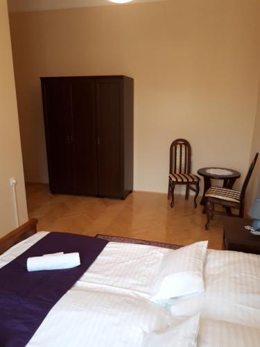 塞格德萨那贝拉旅馆的卧室配有1张床、1张桌子和1把椅子