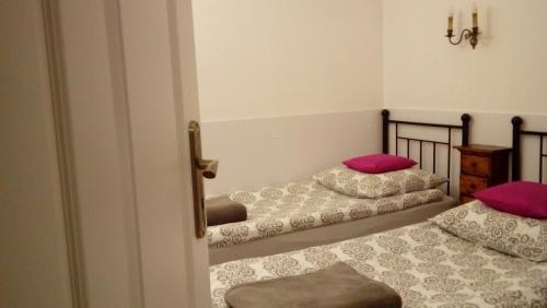 格但斯克Apartament MARIA的配有粉红色枕头的客房内的两张床