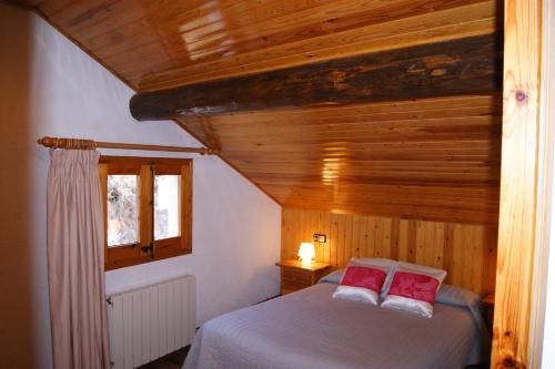 埃斯波特Apartaments Pont Romànic的一间卧室配有一张带两个红色枕头的床