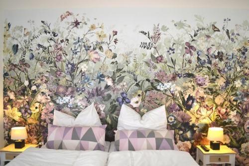 魏玛Ferienwohnung Alexander的卧室配有花卉壁画,毗邻一张床