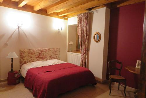贝莱金圣让酒店的一间卧室配有一张带红色毯子的床