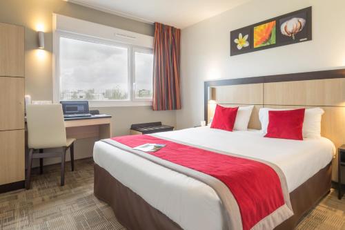 兰斯比萨尼斯兰斯安客市瑞姆斯酒店的酒店客房配有一张床、一张书桌和一台笔记本电脑