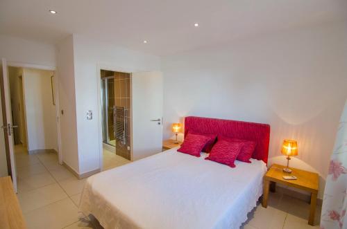 韦尔都勒博Modern 2 Bed Apartment Vale do Lobo的卧室配有带红色枕头的大型白色床