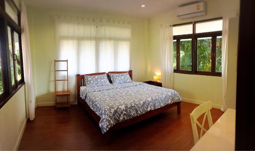 北碧班2莱旅馆的一间卧室设有一张床和两个窗户。