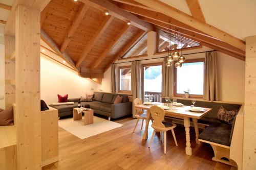 奥蒂塞伊Sule Hof Agriturismo的用餐室和带木制天花板的客厅