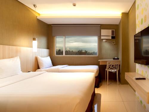 马尼拉Hotel101 - Manila的酒店客房设有两张床和窗户。