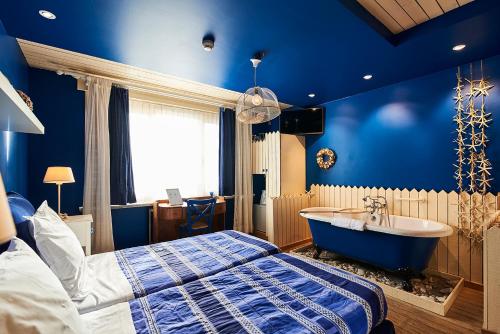 科特赖克客满酒店的卧室配有床和浴缸