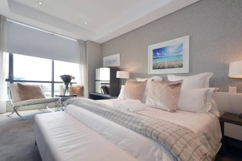 约翰内斯堡615 Sandton Skye的卧室设有一张大白色的床和大窗户
