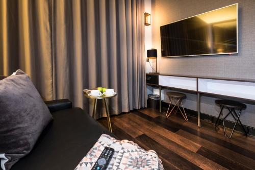 伦敦卡姆登酒店的一间配备有沙发及一张桌子及电视的房间