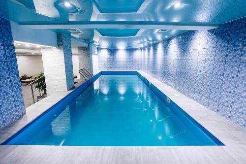 阿拉木图瑞尼恩公园酒店的蓝色瓷砖建筑中的游泳池