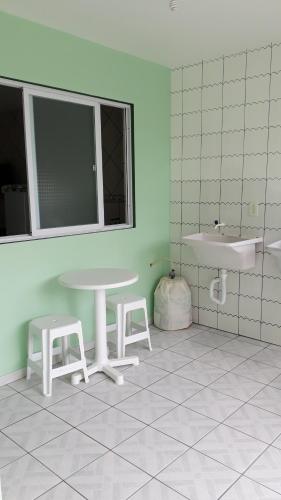 弗洛里亚诺波利斯Pousada Mar Verde的浴室设有桌子、两个凳子和水槽