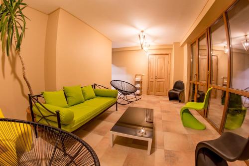 古多里Hotel Deka的客厅配有绿色沙发和椅子