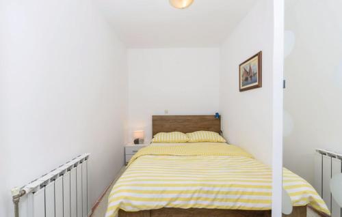 达鲁瓦尔Apartman Mira的一间卧室配有一张带黄白色条纹毯子的床