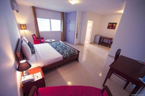 利伯维尔Hotel Adagio的酒店客房配有一张床铺、一张桌子和一张书桌。