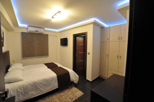 约阿尼纳迪卢索之家酒店的一间白色床和蓝色灯的卧室