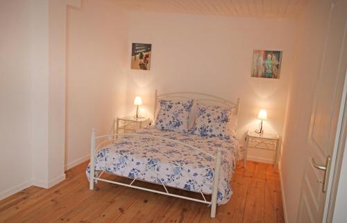 大圣富瓦Cottage at 7的一间卧室配有一张白色床、花卉床罩和两盏灯。