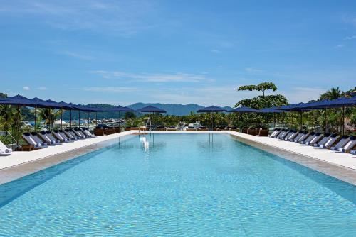 安格拉杜斯雷斯Hotel Fasano Angra dos Reis的一个带躺椅和蓝伞的大型游泳池