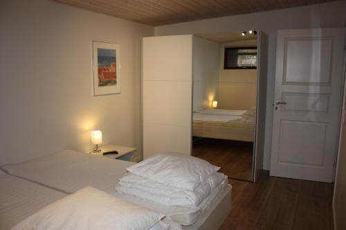 斯卡恩Skagen Ferie 1的一间卧室设有两张床、镜子和门