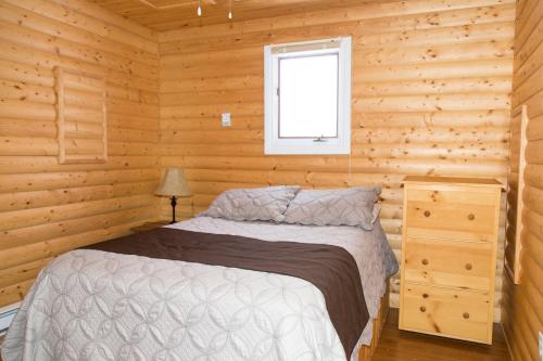 RaleighBurnt Cape Cabins的小木屋内一间卧室,配有一张床