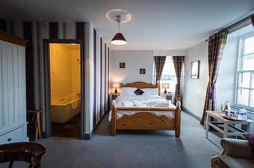 科布里奇The Dyvels Inn的一间卧室配有一张床和一个浴缸。