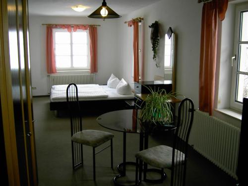 BergaLandhotel am Fuchsbach的配有一张床和一张桌子及椅子的房间