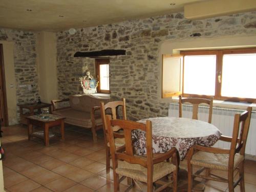 NocecoHotel rural Valtarranz的配有桌椅和石墙的房间