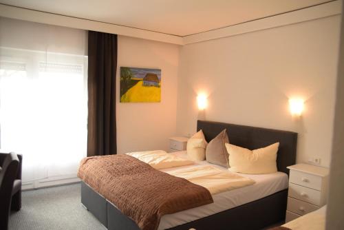 普夫龙滕罗浮鲁腾兰德酒店的一间卧室配有一张带棕色毯子的床