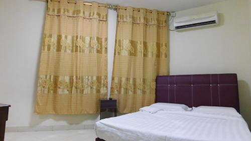 拿笃海洋酒店的一间卧室配有床和带窗帘的窗户