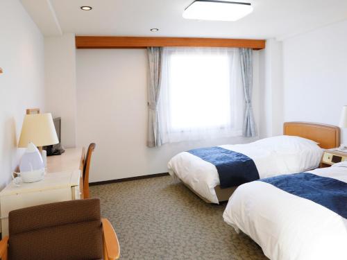 新宫市格兰大酒店的酒店客房设有两张床和窗户。
