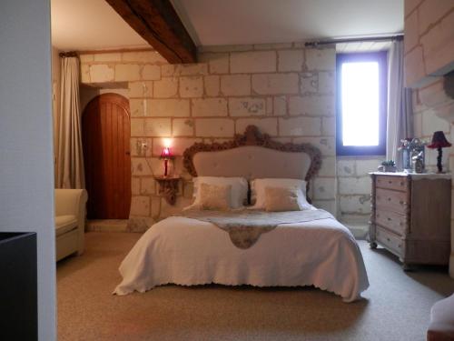 蒙索罗le prieuré的一间卧室设有一张床和石墙