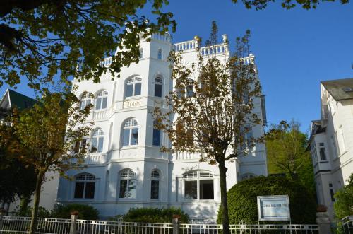 宾茨Villa Sirene - Wohnung 08的前面有棵树的白色建筑