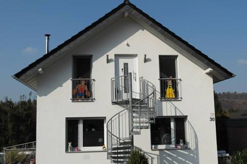 施托尔贝格山林小屋; 冯布里克度假公寓的白色房子,阳台上有两人