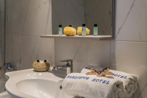 凯法洛斯克尔迪斯托斯酒店的浴室配有盥洗盆、镜子和毛巾