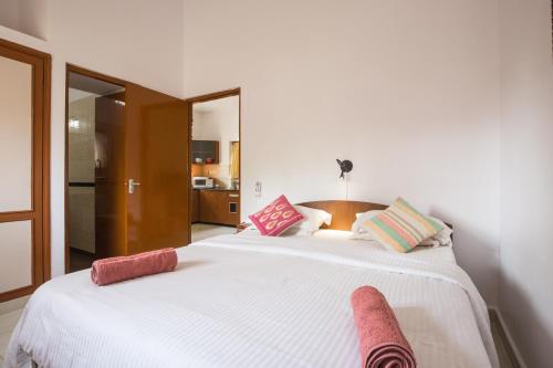 卡乌罗西姆Tobias Villas的卧室配有带粉红色枕头的大型白色床