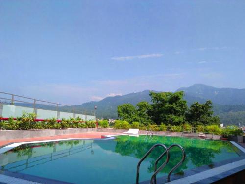 瑞诗凯诗Hotel Natraj Rishikesh的山景游泳池