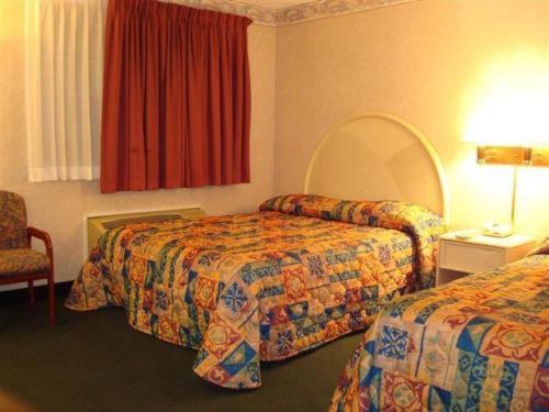 席勒公园奥黑尔套房酒店的酒店客房,配有两张床和椅子