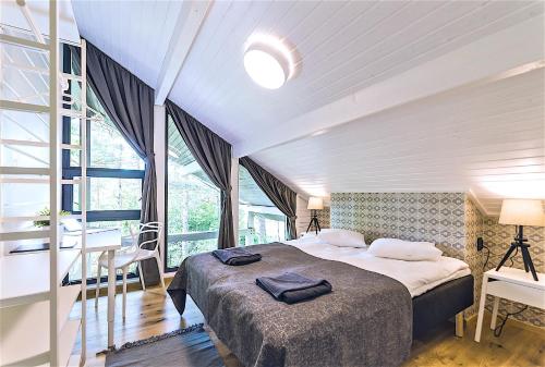 哈普萨卢Hapsal Spa Villas的一间卧室设有一张大床和一个大窗户