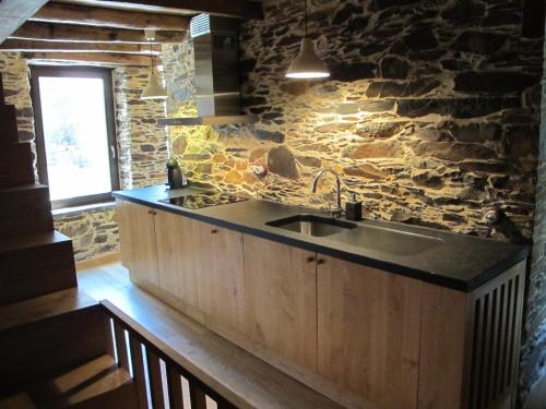 洛萨Casa do Talasnal的一个带水槽和石墙的厨房