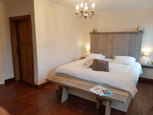 韦伦Widdingenhof的卧室配有一张白色大床和木制床头板