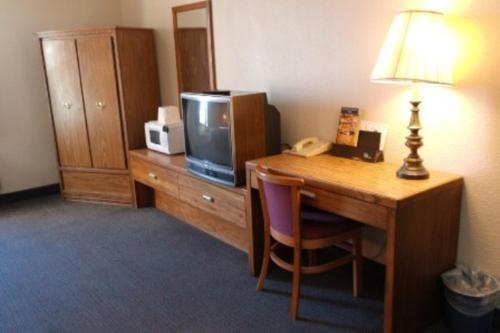 黑格斯敦国行旅馆的酒店客房配有带电视和台灯的书桌。